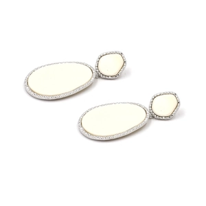 Detail of silver drop earrings with cream oval stones and sparkling pave set crystals