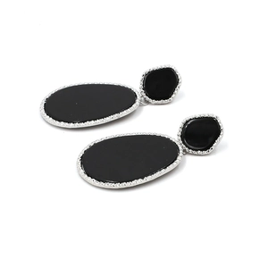 Close-up of teardrop leopard acrylic earrings with silver textured metal borders