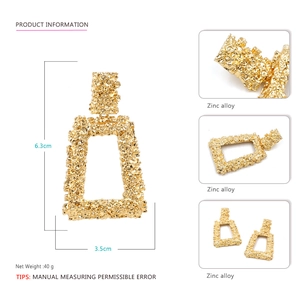 Detail view of large gold geometric earrings featuring textured zinc alloy surface
