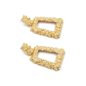 Golden rectangular drop earrings with textured lava finish and bold geometric design