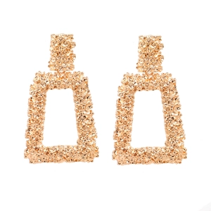 Exaggerated golden geometric earrings with 3D embossed floral patterns on long rectangular studs