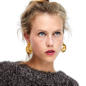 Chic gold-plated hoop earrings with spiral twist texture worn on a female model