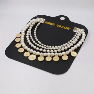Multi-layer pearl necklace featuring vintage gold coin pendants on a fashion display card
