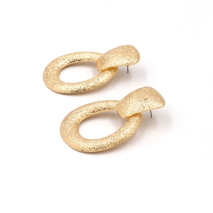 Boucles d'oreilles dorées minimalistes avec finition martelée sur fond blanc pur