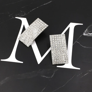 Sparkling silver rectangular earrings with micro-pave crystals on black marble background
