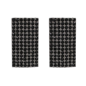Close-up of geometric curved earrings with black rhinestones in a dark metal setting
