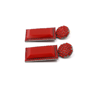 Detail of red geometric drop earrings with rectangular crystals and gunmetal finish