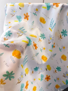 Detailed view of floral silk scarf featuring orange tulips and romantic quotes