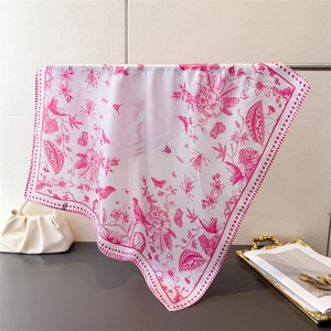 Detail of elegant floral and bird print scarf draped to show silky texture and drape
