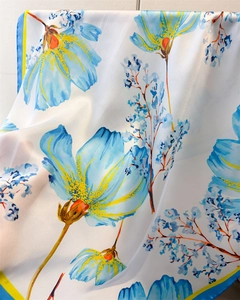 Detail of soft silk-like scarf with blue floral print and contrasting hem stitching