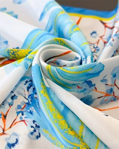 Macro shot of abstract floral silk scarf showcasing glossy satin texture and drape