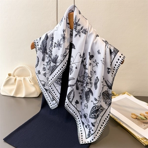 Elegant Toile de Jouy floral and bird print silk scarf hanging on a wooden hanger