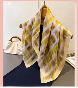 Detail shot of vintage plaid silk scarf in yellow and brown draped on a wooden hanger