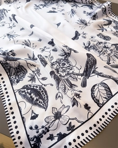 Close-up of silk square scarf featuring black floral and bird toile de jouy pattern