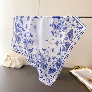 Close-up of elegant blue toile floral print silk scarf featuring birds and butterflies