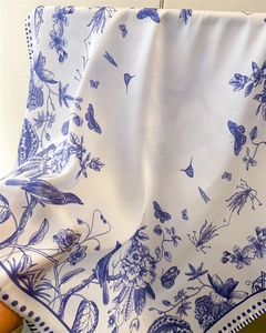 Macro view of blue floral bird pattern on satin silk scarf with soft drape texture