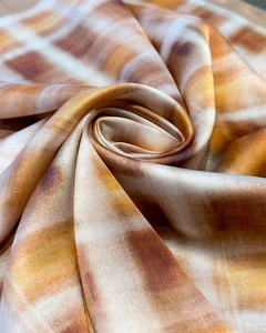 Detail of elegant retro plaid silk scarf with silky texture and orange gradient swirls