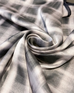 Macro shot of silk-like square scarf showing gray plaid pattern and fine twill weave texture