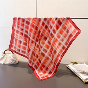 Vintage red plaid silk scarf for women styled on a hanger with a stylish handbag