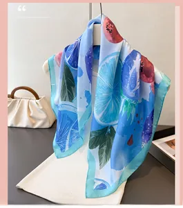 Detailed view of refreshing lemon print on a smooth blue silk scarf for women