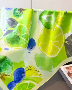 Detailed close-up of lemon and blueberry print on silky fabric with soft satin texture