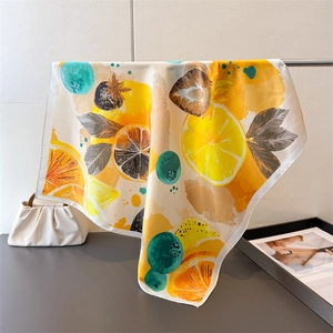 Close-up of lemon and strawberry print on smooth silk scarf with vibrant fruit patterns