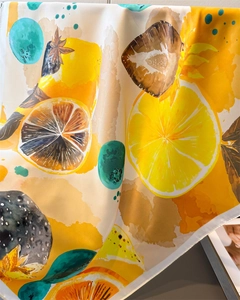 Detailed view of silk-like square scarf featuring vibrant lemon and strawberry prints