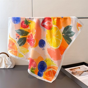 Detailed view of silk square scarf featuring vibrant watercolor lemon and fruit prints