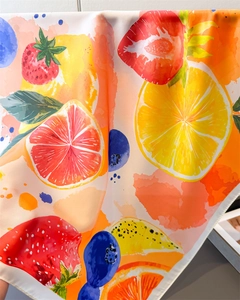Detailed view of the smooth silk texture with vibrant watercolor lemon and fruit prints