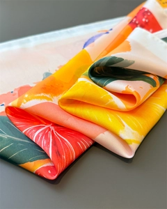 Macro shot of silk scarf showing citrus lemon fruit print and smooth satin texture