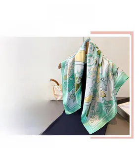 Close-up of floral print square scarf with geometric border in green and yellow