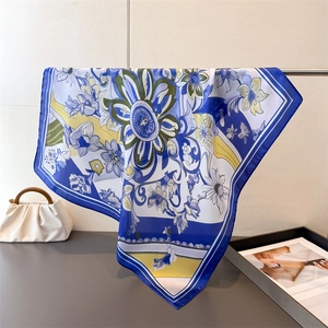 Close-up of elegant floral silk scarf with vibrant blue and yellow abstract flower patterns