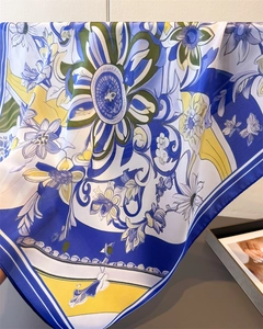 Close-up of vintage floral silk scarf texture with elegant blue and yellow patterns