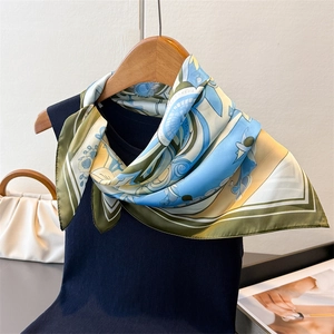 Macro detail of silk-texture square scarf with floral print and rolled hem stitching