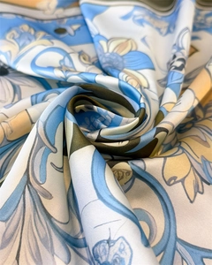 Macro shot of silk satin scarf featuring elegant blue floral vine patterns and glossy texture