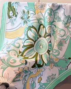 Detail view of floral satin scarf showing mint green and yellow Art Nouveau patterns