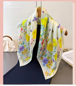 Detail of elegant butterfly print scarf with satin gloss, yellow flowers and green leaves