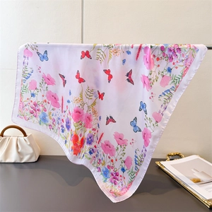 Elegant silk scarf featuring vibrant butterfly and floral prints in soft pink tones