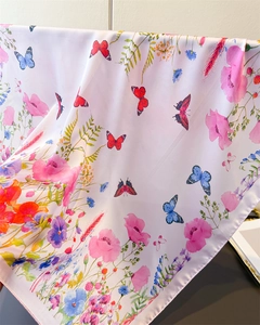 Detailed view of luxury satin silk scarf with colorful butterfly and floral print texture