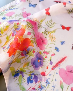 Detailed view of butterfly and floral print on translucent silk-like square scarf