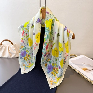 Silk scarf with butterfly and flower prints on cream background draped on a hanger