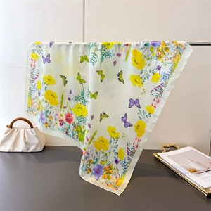 Detail of elegant butterfly and floral print silk scarf hanging in a minimalist setting
