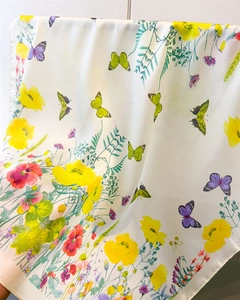 Close-up of lightweight satin scarf with vibrant butterfly and poppy flower prints