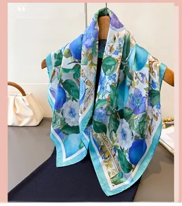 Detail of floral silk scarf with lemon print on a wooden hanger with a chic white bag