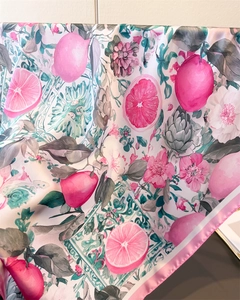 Detailed view of vibrant silk scarf with pink citrus fruit pattern and hand-rolled edges