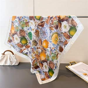 Detail of square silk scarf with vibrant Mediterranean lemon and blue tile prints