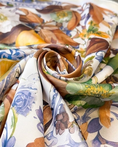 Macro shot of silk scarf with vibrant lemon and floral print in a dynamic spiral fold