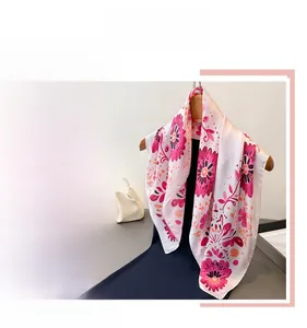 Detailansicht eines Seidenschals mit leuchtenden magentafarbenen Blumenmustern auf Weiß