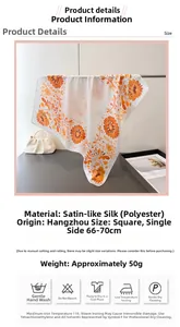 Detailansicht eines eleganten Blumen-Halstuchs mit orangen Blüten und Rollsaum