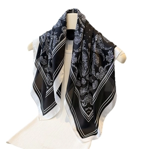Elegant black and white paisley print silk satin square scarf displayed on mannequin